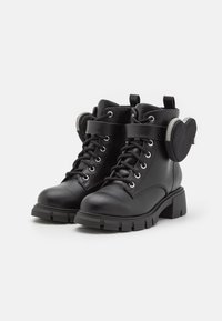 Zwarte leren enkellaarsjes met een ronde neus, vetersluiting en decoratieve band. Voorzien van een stevige blokhak en een hartvormige zak aan de zijkant.