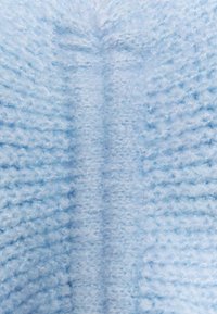 Lichtblauwe gebreide stof met een zachte, pluizige textuur. Het ontwerp heeft een naadloos patroon en subtiele variaties in kleurintensiteit.