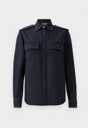Navy shirt with long sleeves, button closure, and two front pockets. Features silver studs on pockets and cuffs, made from a smooth fabric.