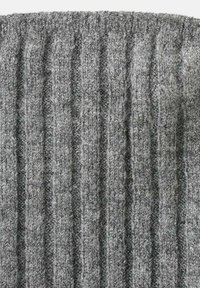 Tessuto a maglia grigio con un motivo a coste. La trama è morbida e pelosa, presenta sezioni alternate in rilievo e abbassate.