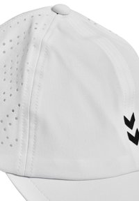 Weißer Hut mit perforierten Abschnitten für Belüftung, runder Krone, flacher Krempe und einem schwarzen Chevron-Akzent an der Seite. Weiches, strukturiertes Material.