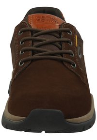 Bruine suede veterschoenen met een tan leren accent, grijze mesh-details en een zwarte rubberen zool met een laag profiel ontwerp.