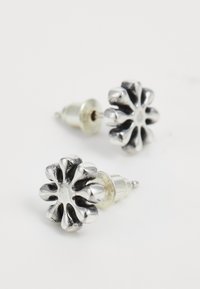 Srebrne studs uhane v obliki cvetov, ki imajo plastičen dizajn latic in polirano površino s teksturiranim središčem.