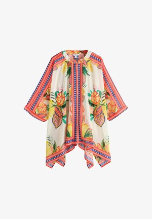 Könnyű krémszínű poncsó színes trópusi gyümölcs- és levélmintákkal, piros és kék geometrikus csíkokkal a szegélyeken és az ujjakon.