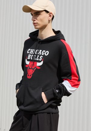 Felpa nera con il testo "CHICAGO BULLS" e una grafica di un toro rosso. Presenta accenti rossi, bianchi e neri sulle maniche, tasca a canguro e cappuccio con coulisse.