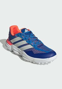 Blue athletic shoe with mesh upper, white three stripes, pink accents, and textured white sole. Features padded collar and reinforced toe.