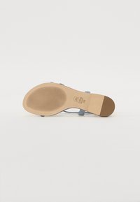 Sandale bleu clair avec un dessus en daim lisse, des brides fines et une semelle matelassée. Comprend une semelle extérieure en caoutchouc texturé pour une bonne adhérence.