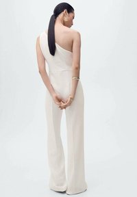 Ljusbeige jumpsuit med enaxel-design, skräddarsydd passform, vida ben och slät textur. Minimalistisk stil utan mönster eller prydnader.