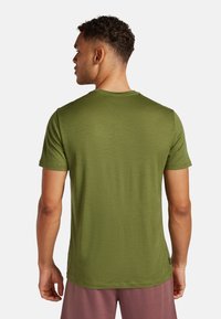 Camiseta de manga corta en verde oliva, hecha de una tela suave, con un cuello redondo clásico y un corte relajado.