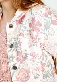 Giacca bomber floreale con una palette di colori pastello che include tonalità di rosa, verde e crema. Realizzata in tessuto leggero con dettagli in metallo sui bottoni.