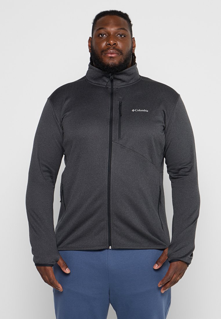 Giacca in pile grigia con colletto alto e zip frontale, dotata di tasche con zip e tessuto texturizzato. Logo Columbia sul petto.