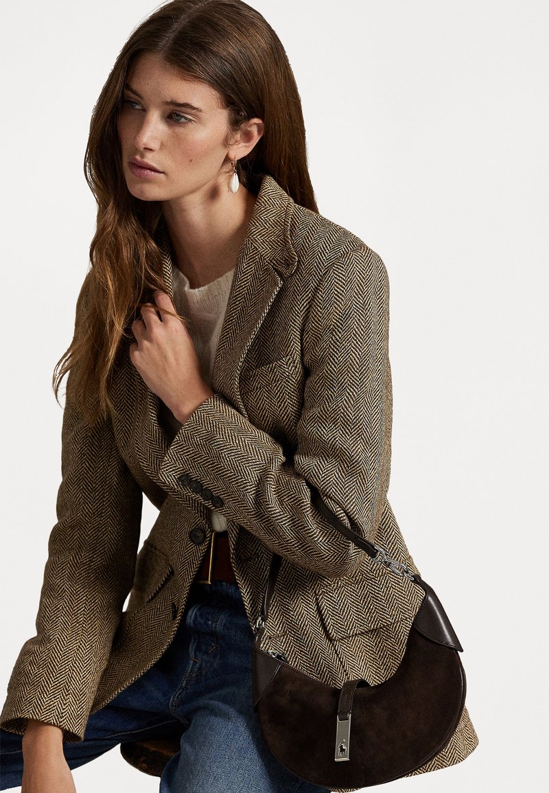 Brown herringbone blazer, lightweight fabric, fitted design. Dark brown circular shoulder bag in suede with leather accents and silver hardware.