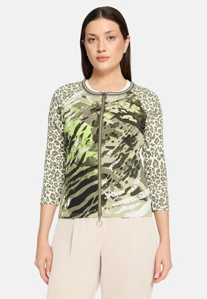 Grøn grafisk zip-up jakke med dyreprintmønstre, trekvartærmel, rund halsudskæring og en metallisk lynlåsdeta.