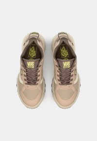 Brune og beige Vans sneakers laget av mesh og syntetiske materialer, med rund tå, snøring foran og teksturert gummisåle.