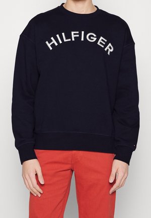 Marineblauwe sweatshirt van katoen, met een groot wit geborduurd "HILFIGER" logo over de borst en ribgebreide boorden en zoom.