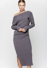 Szara, prążkowana sukienka bez ramiączek z długimi rękawami, dopasowany fason, rozcięcie po stronie oraz okrągły czarny logo akcent na korpusie.