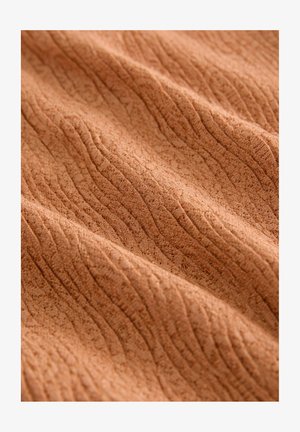 Tissu texturé de couleur terracotta chaude avec un motif froissé. Matériau doux, léger et légèrement extensible.