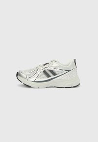 Hvit sportsko med øvre del i mesh, svarte detaljer og refleksdetaljer. Har en polstret såle og snøring.