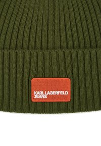 Căciulă tricotată verde, cu nervuri, având un etichete rectangulară portocalie cu text alb în relief care spune "KARL LAGERFELD JEANS."