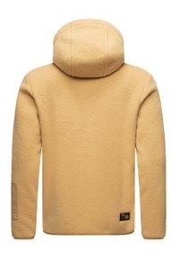 Chaqueta de forro polar beige con capucha, mangas largas, superficie texturizada y un pequeño logotipo en negro cerca del dobladillo inferior derecho en la parte posterior.