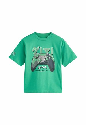 Zielony T-shirt z dużym nadrukiem kontrolera do gier i japońskim tekstem wyśrodkowanym na przodzie oraz dodatkowym tekstem na lewym rękawie.