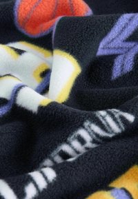Koc z polaru w ciemnym granacie z wielokolorowymi wzorami koszykarskimi i logo drużyny. Miękka faktura z białymi, żółtymi, fioletowymi i pomarańczowymi akcentami.
