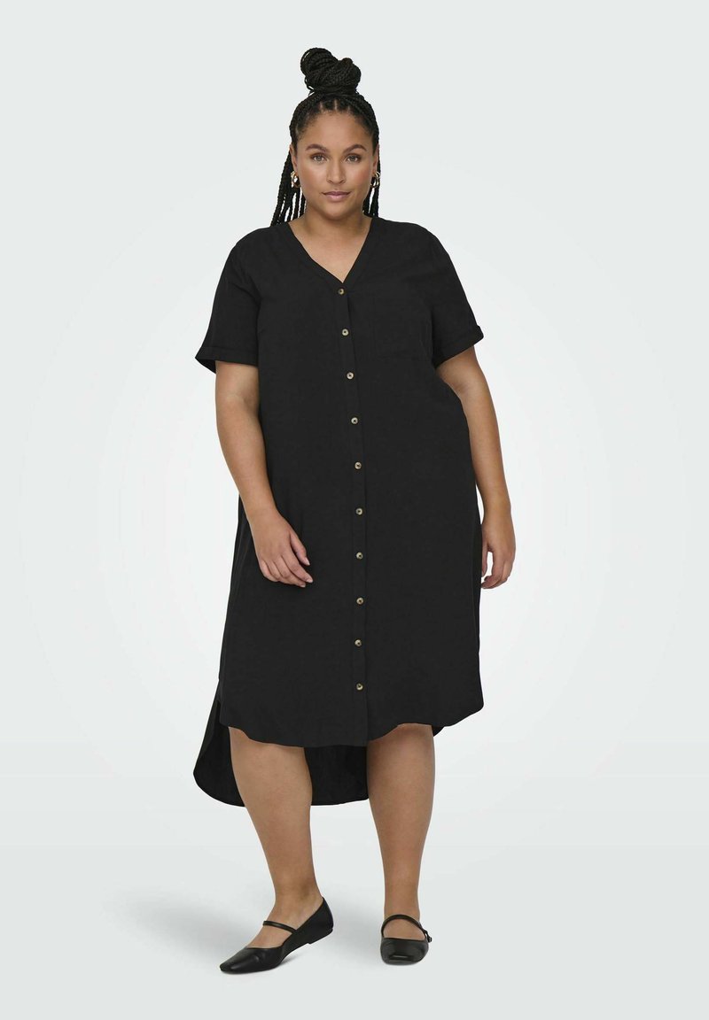 Robe noire boutonnée à manches courtes, décolleté en V et poche poitrine. Équipée de boutons dorés et d'un ourlet arrière plus long. Tissu lisse et léger.