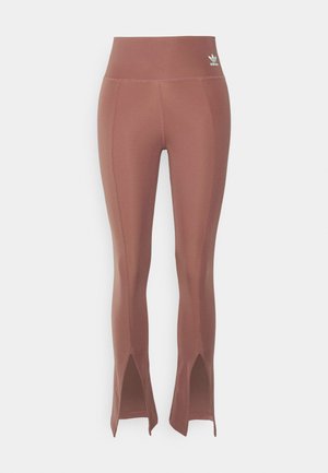 Braune, hoch taillierte Leggings mit seitlichen Schlitzen am Saum, aus dehnbarem Material. Verfügt über dezente Nähte und ein kleines Logo in der Nähe des Bundes.