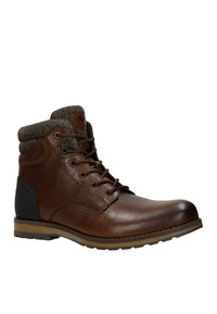 Stivale alla caviglia in pelle marrone con colletto in lana testurizzata, design con lacci, suola in gomma e accentuazione nera sul tallone. Cuciture dettagliate visibili.