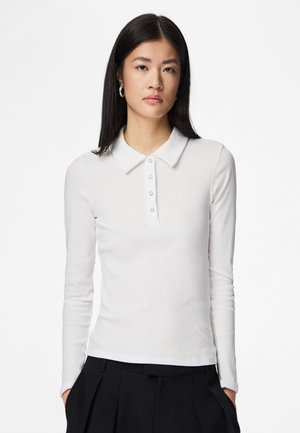 Weißes, langärmeliges Poloshirt mit gerippter Struktur, ausgestattet mit einem Kragen und einer Knopfleiste mit fünf Knöpfen. Kombiniert mit einer hoch taillierten schwarzen Hose.