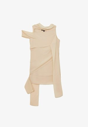 Beige asymmetrische mouwloze jurk met gelaagde stofdetails en een lange vloeiende panel aan één kant, plat gevouwen op een witte achtergrond.
