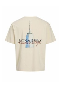 Beige puuvillane T-särk, mille seljal on kõrghoone graafika ja tekst "JACK & JONES Loovosakond". Lühikesed varrukad.