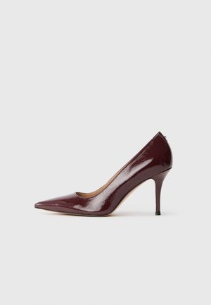 Burgundy läikivast nahast king, millel on terav nina, madal vamps ja peen stiletto konts. Sile tekstuur ja minimalistlik disain.