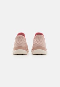 Sneaker rosa chiaro con superficie testurizzata, tacco rosa scuro a contrasto e suola in gomma bianca. Design minimalista senza lacci visibili.