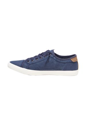 Marineblaue Canvas-Sneaker mit niedrigem Schaft, weißer Sohle, marineblauen Schnürsenkeln, Metallösen und braunem Fersenpatch auf einfarbigem Hintergrund.