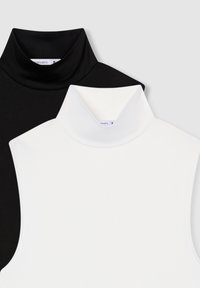 Due turtlenecks senza maniche, uno nero e uno bianco, realizzati in tessuto liscio ed elasticizzato. Presentano colli alti e nessuna cucitura visibile.