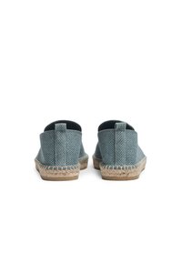 Blauwe canvas espadrilles met een geweven textuur, juten zool en gestikte details. Laag uitgesneden achterkant met een eenvoudige trekband.