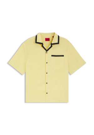 Lichtgeel overhemd met korte mouwen en knopen, met zwarte bies op de kraag en zak, rode merkembleem binnenin de kraag.