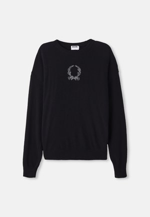 Schwarzer Pullover mit Rundhalsausschnitt, langen Ärmeln und gerippten Bündchen. Besitzt ein weißes, gesticktes Kranz- und Schleifendetail auf der Vorderseite.