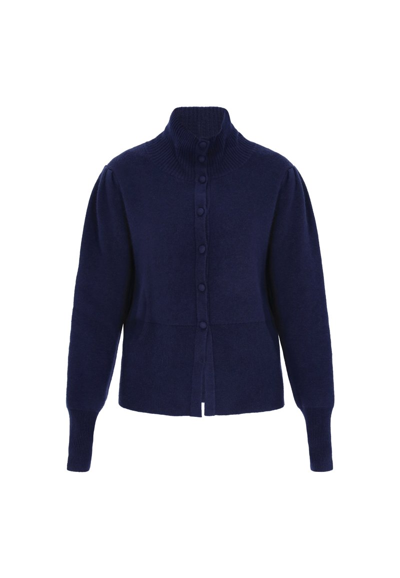 Marinblå stickad cardigan med hög ribbad krage, sex framknappar och ribbade ärmslut. Har puffärmar och en kortad design.