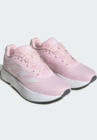 Jasnoróżowe buty sportowe wykonane z oddychającej siateczki i tekstyliów. Posiadają białe akcenty oraz sznurowadła, a także amortyzowaną podeszwę i podeszwę z gripem.