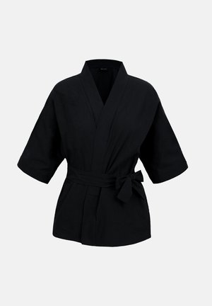 Chaqueta cruzada estilo kimono negra con mangas anchas de tres cuartos y cinturón atado en la cintura sobre un fondo liso.