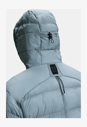 Light blue puffer jacket featuring a hood, quilted texture, and an adjustable toggle at the back with a black accent plate.