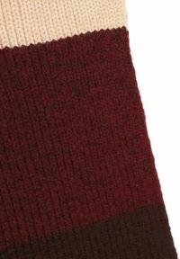 Knit fabric featuring three horizontal stripes: cream, burgundy, and dark brown. Textured, warm wool material with a smooth finish.