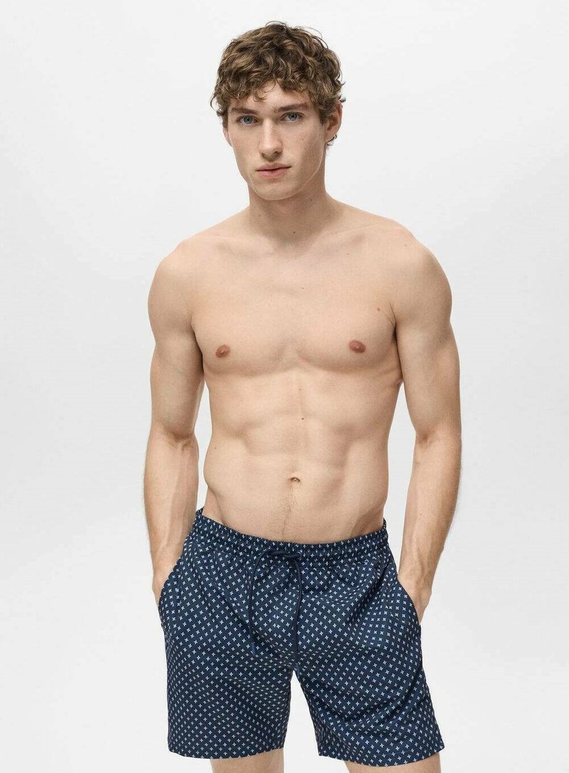 Pantalonii de baie bleumarin au un model geometric alb, o talie elastica cu siret si doua buzunare laterale. Materialul pare usor.