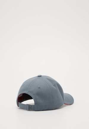 Lysegrå justerbar baseballkasket med metalspænde og seks ventilationshuller, vist bagfra og fra siden på hvid baggrund.