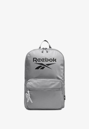 Zaino grigio Reebok con tasca frontale con cerniera, logo nero, manico superiore e cursore della cerniera bianco a forma di aeroplano.