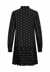 Juoda suknelė su ilgomis rankovėmis ir sagų užsegamu apykakliu, puošta baltais taškeliais, klostuota sijonu ir sagomis užsegamais rankogaliais.