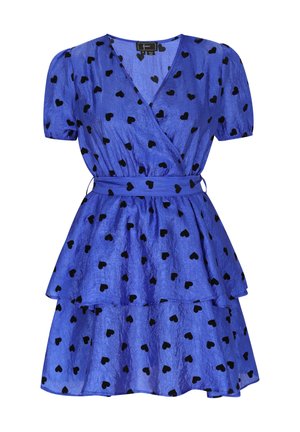 Modra obleka s črnimi srčkastimi vzorci, kratkimi nabranimi rokavi, večplastnim krilom in pasom. Narejena iz teksturirane tkanine.