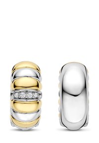 Zwei Ringe angezeigt. Der eine hat ein Gold- und Silberdesign mit gerippten Details und drei kleinen Diamanten; der andere ist aus poliertem Silber.